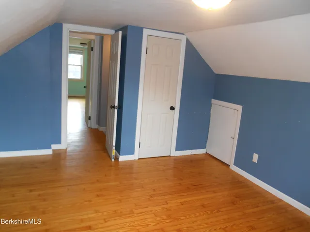 a view of a big room with wooden floor and windows