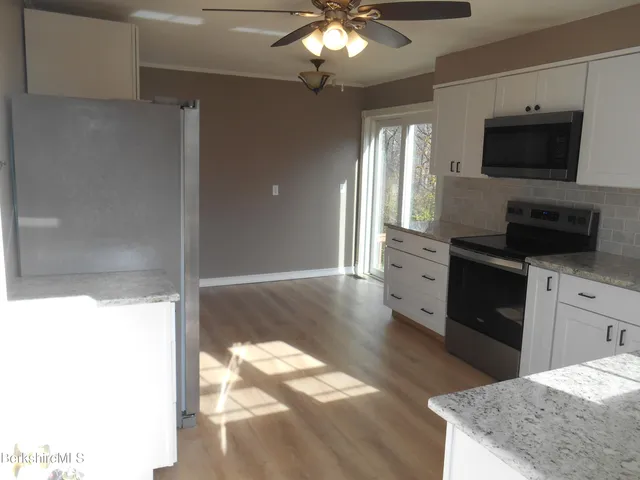 a kitchen with a refrigerator and a stove top oven