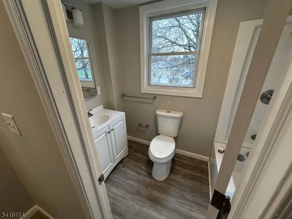 a white toilet sitting next to a window in a bathroom