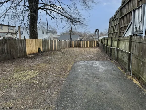 a view of backyard with wooden fence
