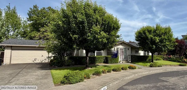 a front view of a house with a yard and trees