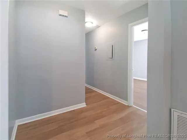 an empty room with wooden floor and mirror