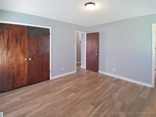 a view of an empty room with wooden floor