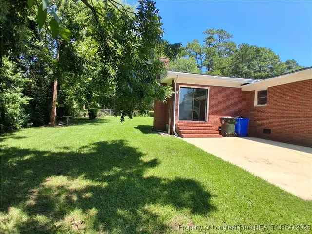a backyard of a house with yard and outdoor seating