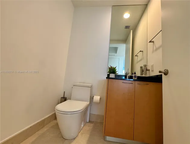a bathroom with a toilet and a mirror