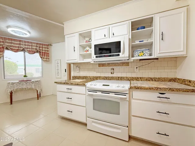 a kitchen with white cabinets and white appliances