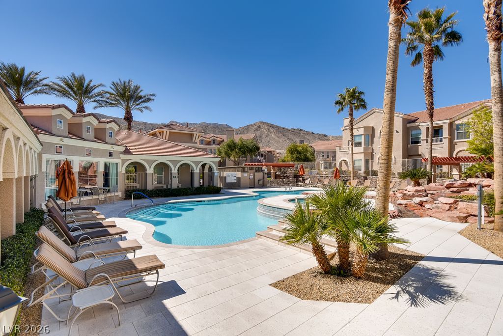 10550 West Alexander Road, Unit 1108 Las Vegas, NV 89129 - Photo 22 of 29 Community pool & spa, with lush palm trees framing the views.