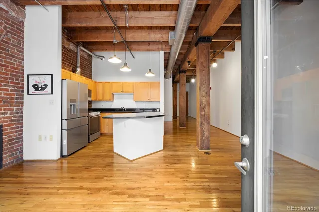 a kitchen with stainless steel appliances granite countertop a sink a stove and a refrigerator