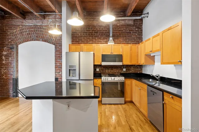 a view of a kitchen with refrigerator and wooden floor