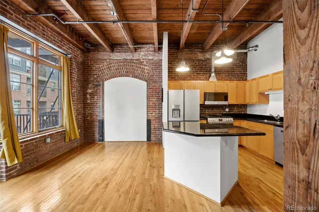 a kitchen with stainless steel appliances granite countertop a sink and a wooden floors