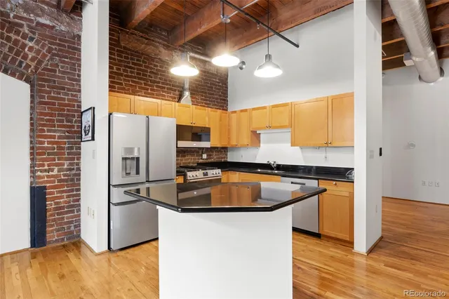 a kitchen with stainless steel appliances granite countertop a refrigerator a sink and a stove