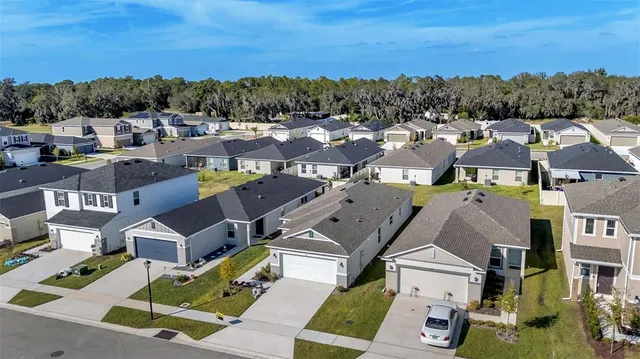 an aerial view of residential houses with outdoor space and ocean view
