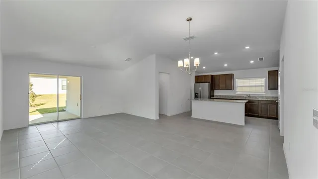 a view of kitchen with kitchen island stainless steel appliances a sink counter space and a window