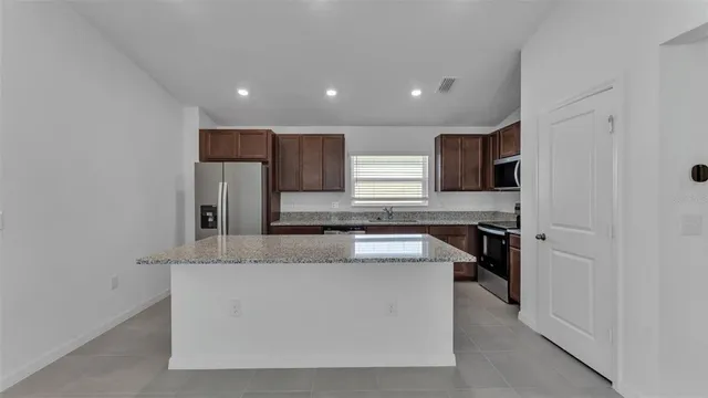 a large kitchen with stainless steel appliances granite countertop a granite counter tops and a sink