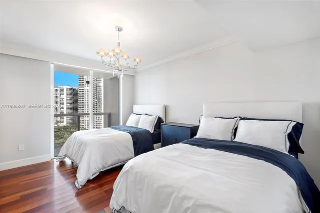 a bedroom with two beds and a large window