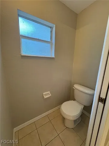 a white toilet sitting next to a white sink and vanity
