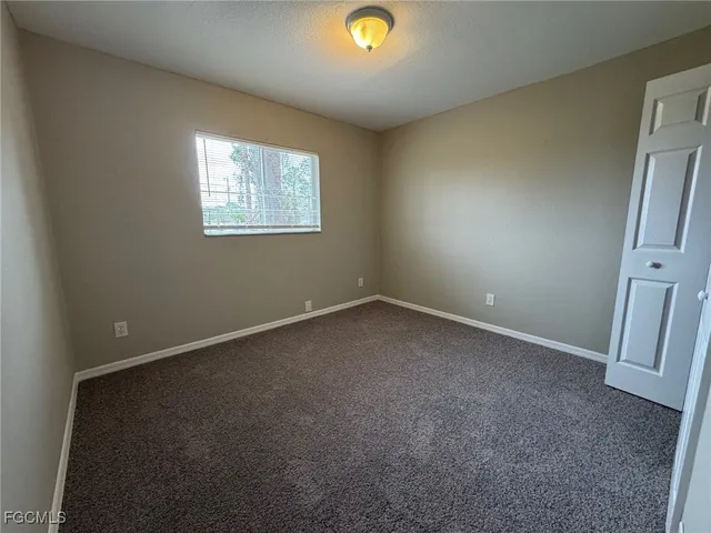 an empty room with window and stairs