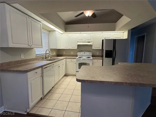 a kitchen with a sink a counter top space cabinets and stainless steel appliances