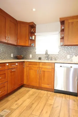 a kitchen with granite countertop a refrigerator and a stove top oven