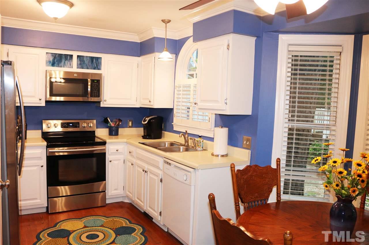4508 Tetbury Place Raleigh, NC 27613 - Photo 11 of 22 a kitchen with a stove a sink and a refrigerator