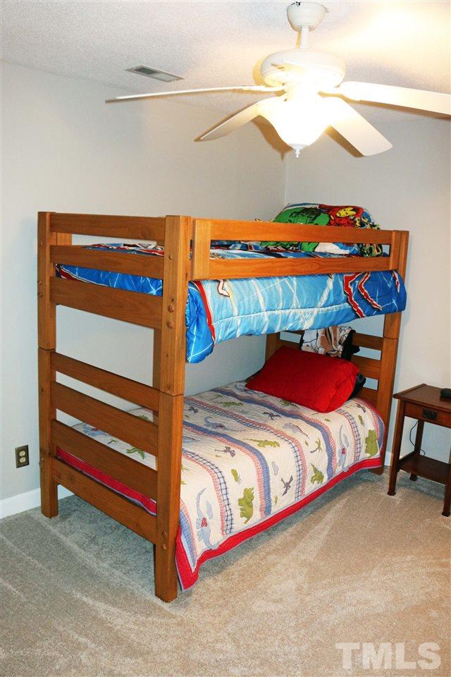 4508 Tetbury Place Raleigh, NC 27613 - Photo 22 of 22 a bed sitting in a bedroom next to a lamp