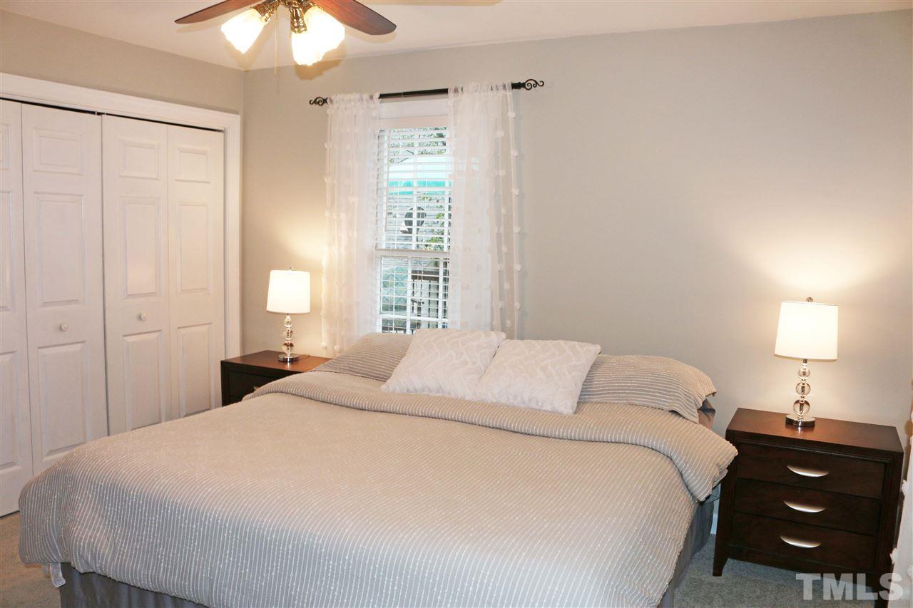 4508 Tetbury Place Raleigh, NC 27613 - Photo 9 of 22 a bedroom with a bed and a lamp