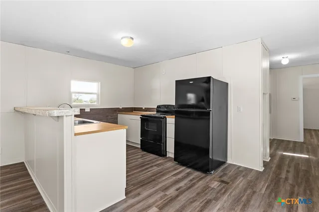 a kitchen with a refrigerator and a stove top oven