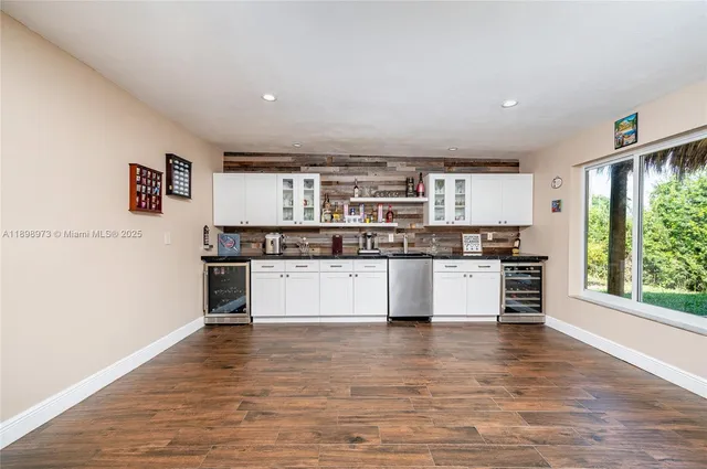 a large white kitchen with stainless steel appliances granite countertop a stove and a refrigerator