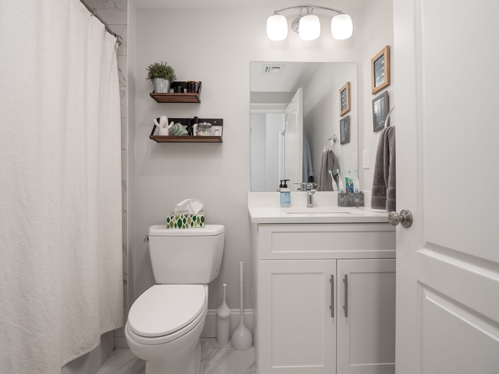 45 L Street, Unit 2 Boston, MA 02127 - Photo 16 of 31 a bathroom with a toilet a sink and mirror