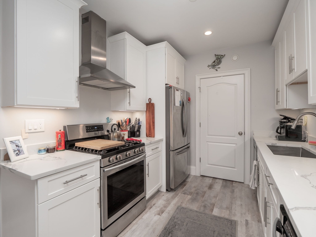 45 L Street, Unit 2 Boston, MA 02127 - Photo 19 of 31 a kitchen with stainless steel appliances granite countertop a sink stove and refrigerator