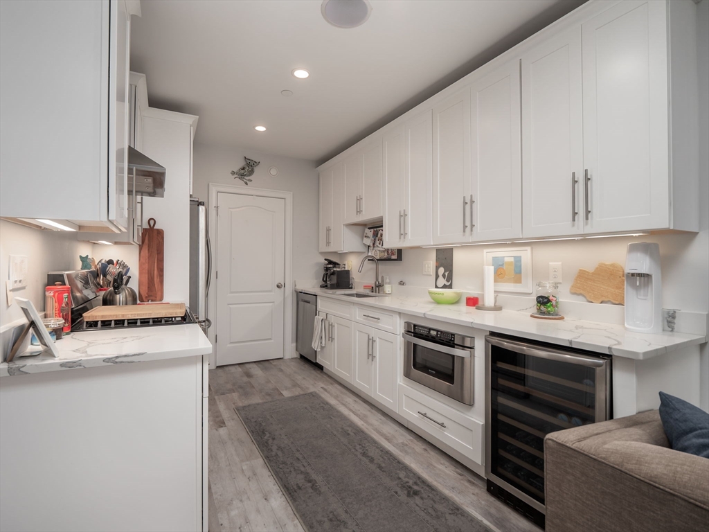 45 L Street, Unit 2 Boston, MA 02127 - Photo 8 of 31 a kitchen with stainless steel appliances granite countertop a sink stove oven and white cabinets