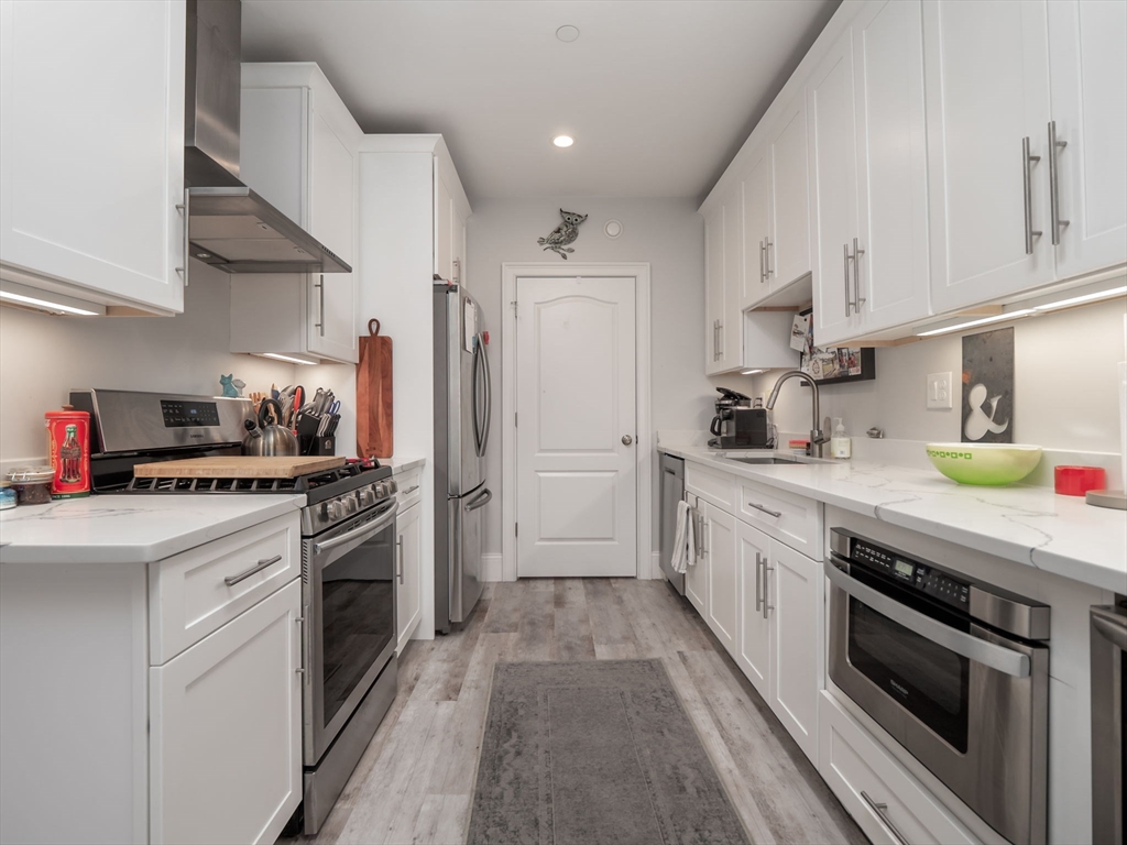 45 L Street, Unit 2 Boston, MA 02127 - Photo 9 of 31 a kitchen with stainless steel appliances granite countertop a sink a stove and a refrigerator