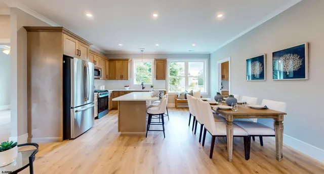 a kitchen with sink a refrigerator and chairs