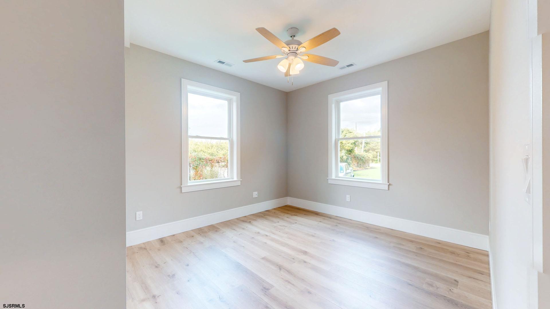 1729 Shore Road Ocean View, NJ 08230 - Photo 20 of 36 an empty room with wooden floor and windows