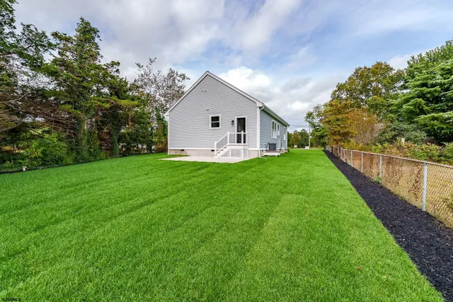 a view of a house with a yard and pathway