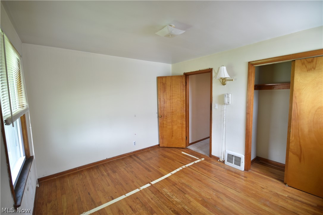 31921 Pendley Road Willowick, OH 44095 - Photo 13 of 22 Unfurnished bedroom with a closet, light hardwood / wood-style flooring, and multiple windows