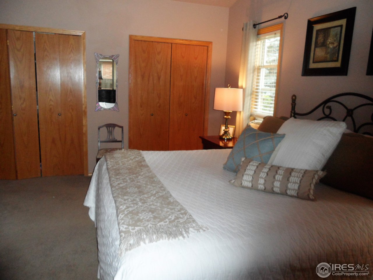 724 Wade Road Longmont, CO 80503 - Photo 13 of 32 a bedroom with a bed and dresser with mirror