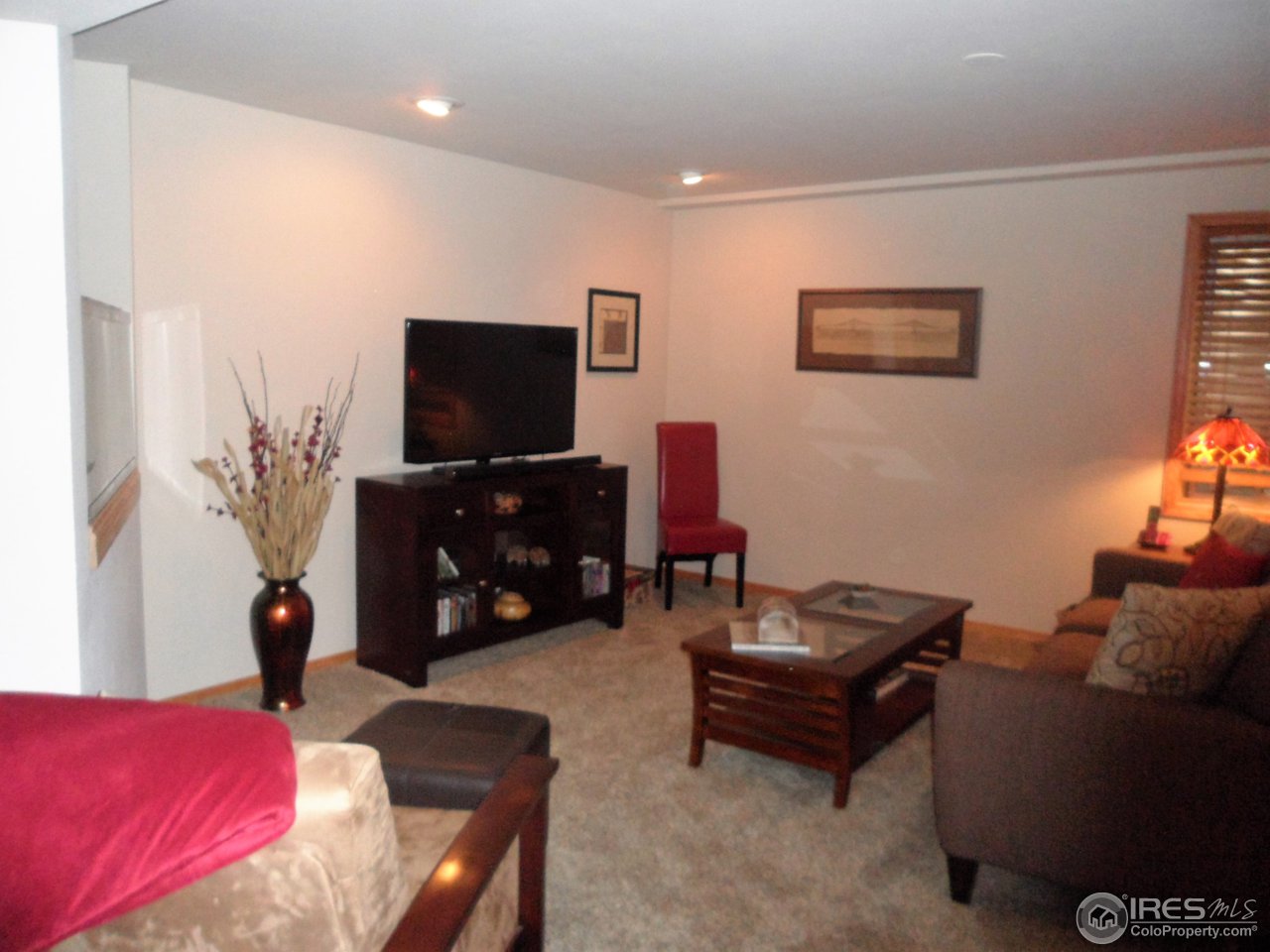 724 Wade Road Longmont, CO 80503 - Photo 18 of 32 a living room with furniture and a flat screen tv