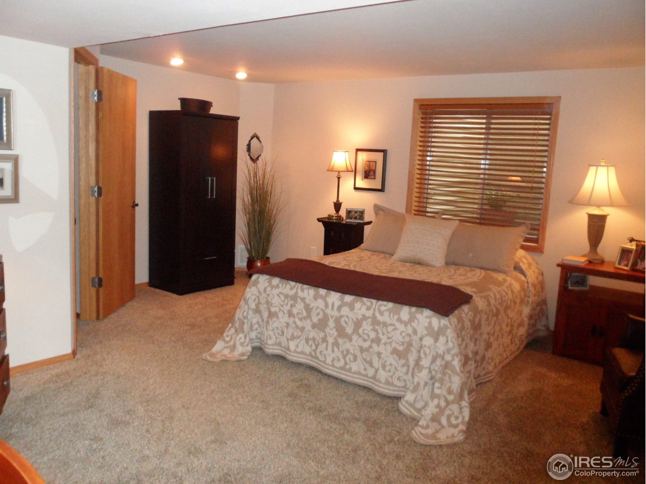 724 Wade Road Longmont, CO 80503 - Photo 22 of 32 a bedroom with a bed and a lamp