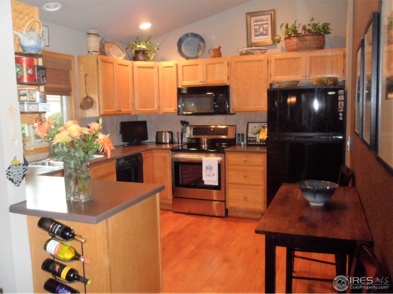 724 Wade Road Longmont, CO 80503 - Photo 5 of 32 a kitchen with stainless steel appliances granite countertop a sink dishwasher stove and refrigerator with wooden floor