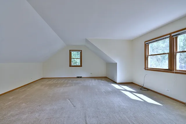a spacious bedroom with a bed and windows