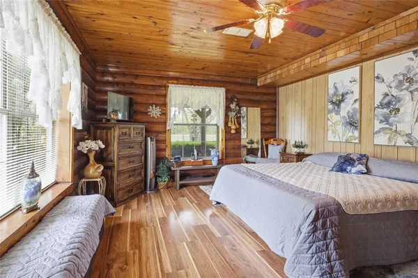 a bed sitting in a spacious bedroom next to a window