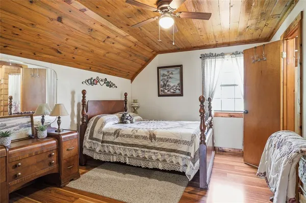 a bedroom with a bed and wooden floors