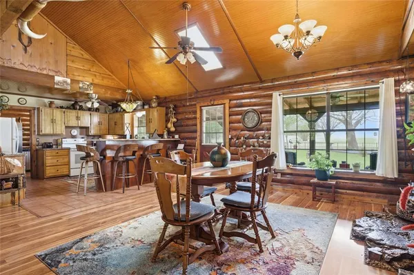a dining room with furniture a chandelier and wooden floor