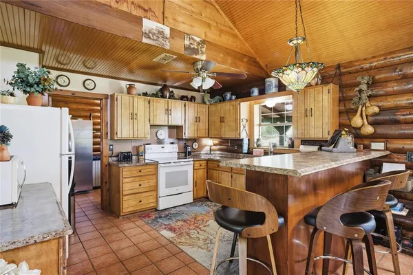 a kitchen with cabinets and chairs