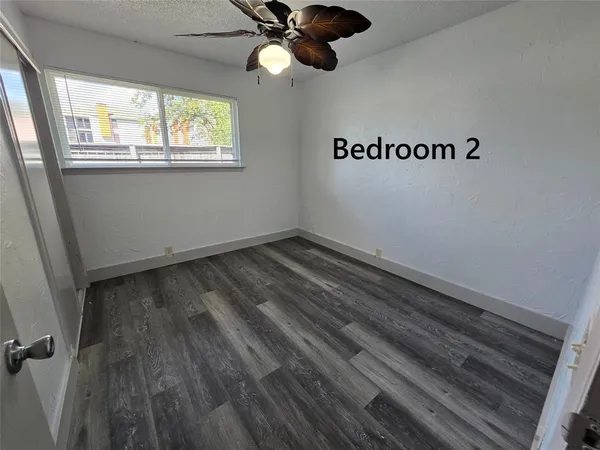 a view of a room with wooden floor and ceiling fan