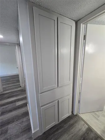 a view of front door with hallway and wooden floor