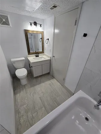 a bathroom with a sink mirror vanity and toilet