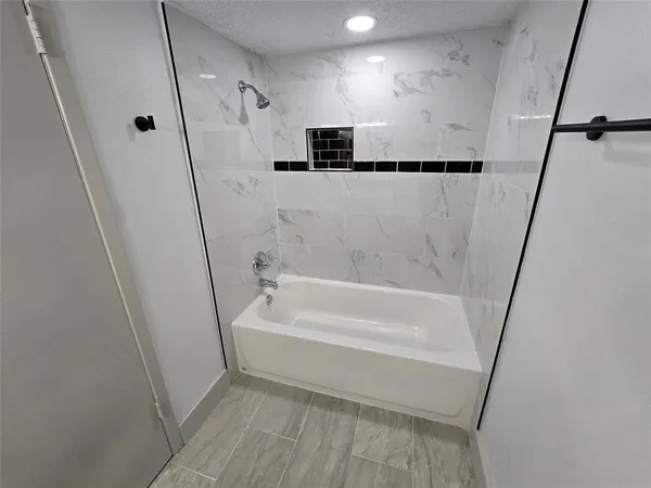 a bathroom with a tub a sink and a shower