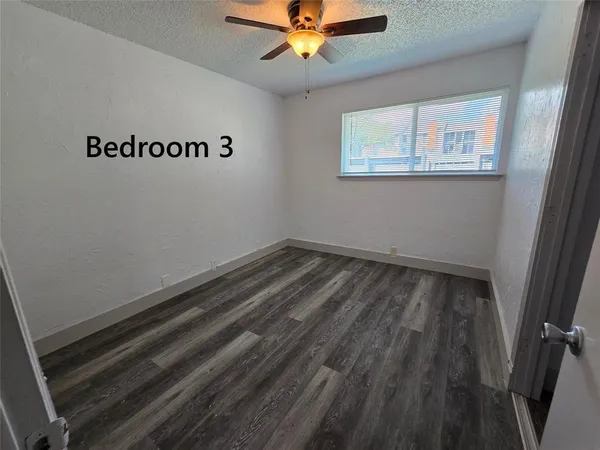 a view of a room with wooden floor and fan